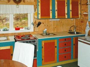 a kitchen with red and blue cabinets and a sink at 3 person holiday home in Frei-By Traum in Frei +16 photos