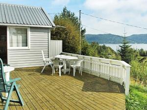 um deque de madeira com uma mesa e cadeiras numa casa em One-Bedroom Holiday home in Frei em Frei