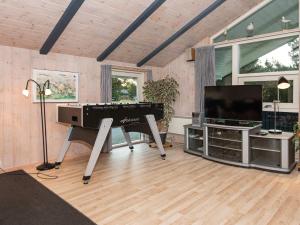 Il comprend un salon avec un piano et une télévision à écran plat. dans l'établissement 8 person holiday home in Bl vand, à Blåvand