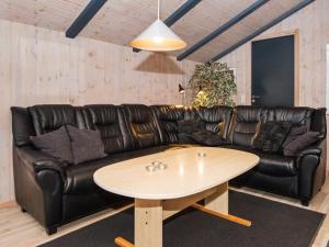 ブラーバンドにある8 person holiday home in Bl vandの黒い革張りのソファ(コーヒーテーブル付)