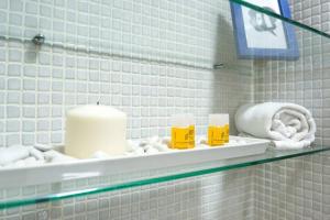 a glass shelf in a bathroom with towels and candles at TGH Málaga centro histórico - Calle Alamos in Málaga