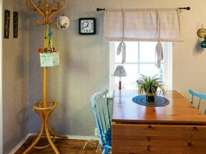 a dining room with a wooden table with chairs and a clock at 5 person holiday home in FALKENBERG-By Traum in Falkenberg +8 photos
