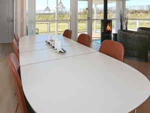 een witte tafel en stoelen in een kamer met een open haard bij Holiday Home Kystvejen in Haslevgårde