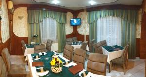 a dining room with tables and chairs and a television at Veliki Raj Plus in Stenjevac