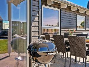 a grill on a patio with a table and chairs at 12 person holiday home in Hasselberg in Kappeln