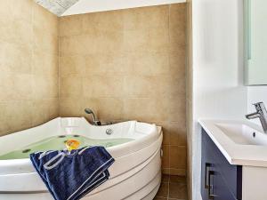 a bathroom with a tub and a sink at 12 person holiday home in Hasselberg in Kappeln