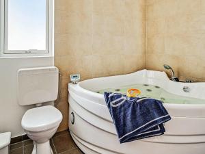 a bathroom with a tub and a toilet and a sink at 12 person holiday home in Hasselberg in Kappeln