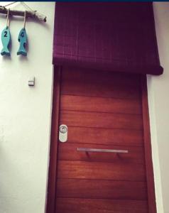 a wooden door in a room with two hooks at La Calita del Versalles in Cullera