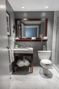 a bathroom with a toilet and a sink and a mirror at Westminster Hotel in Livingston
