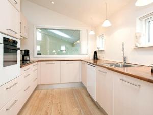 a white kitchen with a window and a sink at 12 person holiday home in V ggerl se in Marielyst