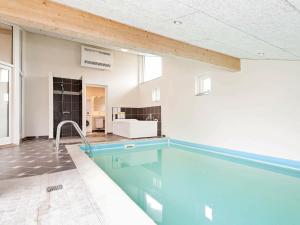 a large swimming pool in a room with a bathroom at 12 person holiday home in V ggerl se in Marielyst