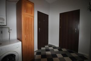 a laundry room with two doors and a checkered floor at Ali 2 in Sosnowiec