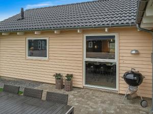 ein Haus mit einer Terrasse mit Stühlen und einem Grill in der Unterkunft 10 person holiday home in Hasselberg in Kappeln