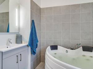 ein Badezimmer mit einer weißen Badewanne und einem Waschbecken in der Unterkunft 10 person holiday home in Hasselberg in Kappeln