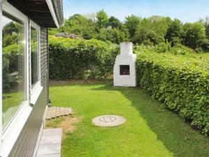 a backyard with a fireplace on the side of a house at 4 person holiday home in Juelsminde in Sønderby