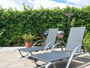 two chairs sitting next to each other on a patio at 4 person holiday home in Juelsminde in Sønderby