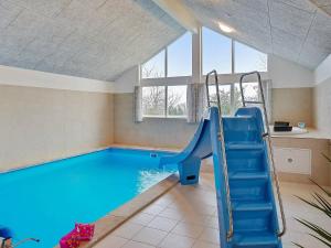 a swimming pool with a slide in a room at 18 person holiday home in Hasselberg in Kappeln