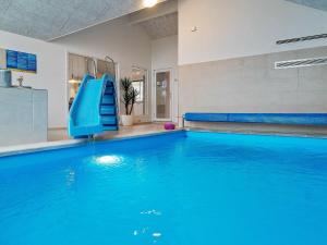 a swimming pool with a blue slide in a building at 18 person holiday home in Hasselberg in Kappeln
