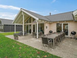 a patio with a table and chairs and a house at 18 person holiday home in Hasselberg in Kappeln