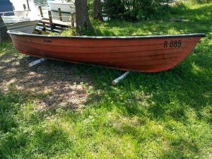 a wooden boat sitting on the grass in a field at 4 person holiday home in Silkeborg in Silkeborg
