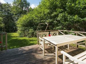 シルケボーにある4 person holiday home in Silkeborgの木製デッキ(白いテーブルと椅子付)