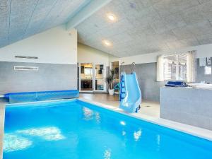 ein Pool mit blauer Rutsche in einem Haus in der Unterkunft 30 person holiday home in Bogense in Bogense