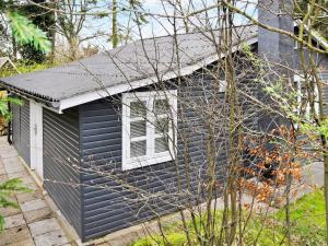 a black house with a window on the side of it at 5 person holiday home in Ans By in Roe