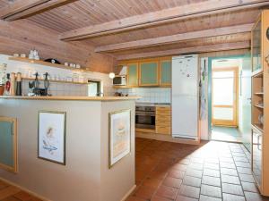 Fjellerupにある8 person holiday home in Glesborgのタイルフロアのキッチン(白い冷蔵庫付)
