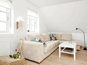 uma sala de estar branca com um sofá e uma mesa em 8 person holiday home in L kken em Løkken
