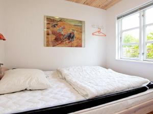a bed in a bedroom with a painting on the wall at 6 person holiday home in Store Fuglede in Store Fuglede