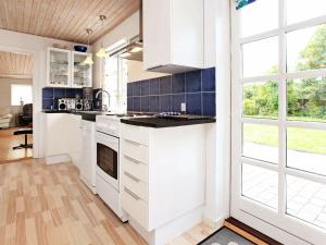 a kitchen with white cabinets and a large window at 6 person holiday home in Store Fuglede in Store Fuglede