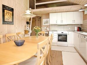Fjerritslevにある8 person holiday home in Fjerritslevのキッチン(大きな木製テーブル、椅子付)
