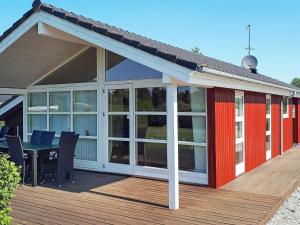 a screened in deck with a table and chairs at 6 person holiday home in Dannemare in Dannemare