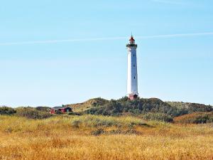 a lighthouse on top of a hill with a field at 6 person holiday home in Hvide Sande in Hvide Sande