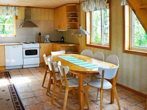 ユシーレにあるFour-Bedroom Holiday home in S-Uddvallaのキッチン(木製テーブル、白い家電製品付)