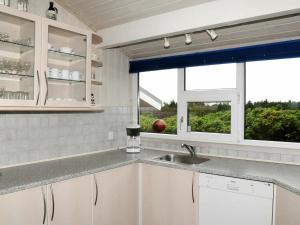 ヘンネ・ストランドにある7 person holiday home in Henneの白いキャビネット、シンク、窓付きのキッチン