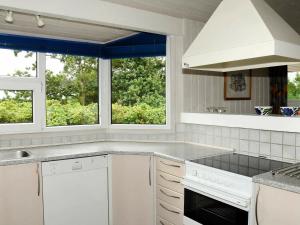 ヘンネ・ストランドにある7 person holiday home in Henneの白い家電製品付きのキッチン、窓2つが備わります。
