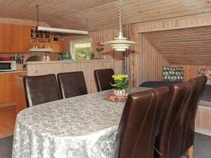 ein Esszimmer mit einem Tisch und Ledersesseln in der Unterkunft Holiday home Nørre Nebel XXI in Nørre Nebel