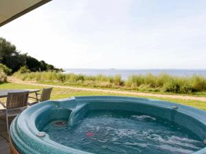 a hot tub on a patio with a view of the ocean at 7 person holiday home in Stege in Stege