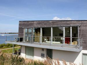 a house with a balcony with a view of the water at 7 person holiday home in Stege in Stege