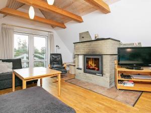 a living room with a fireplace and a tv at 16 person holiday home in Vestervig in Vestervig