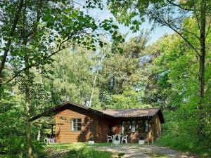 eine Blockhütte inmitten eines Waldes in der Unterkunft Three-Bedroom Holiday home in Rønne 4 in Rønne