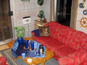 Tangstadにある6 person holiday home in B stadのリビングルーム(赤いソファ、テーブル付)