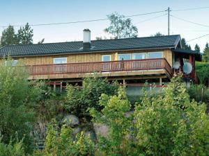 una casa de madera con terraza en una colina en Two-Bedroom Holiday home in Vågland 4 en Rabben