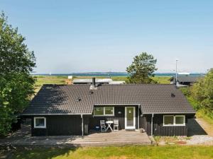 ein schwarzes Haus mit Veranda und Terrasse in der Unterkunft 8 person holiday home in Ebeltoft-By Traum in Ebeltoft