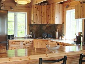 UalandにあるThree-Bedroom Holiday home in Ualandのキッチン(木製キャビネット、大きな木製テーブル付)