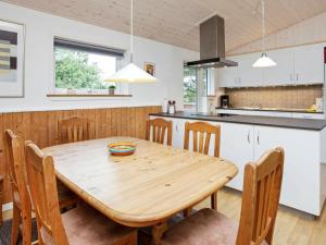 a kitchen and dining room with a wooden table and chairs at 6 person holiday home in Jerup in Jerup