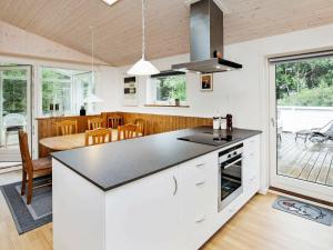 a kitchen and dining room with white cabinets and a table at 6 person holiday home in Jerup in Jerup