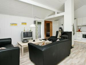 een woonkamer met een bank en stoelen en een tv bij 6 person holiday home in lb k in Ålbæk