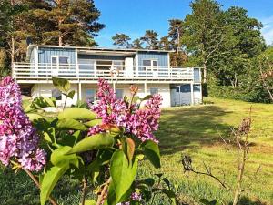 a house on a hill with flowers in front of it at 8 person holiday home in LJUNGSKILE in Ljungskile